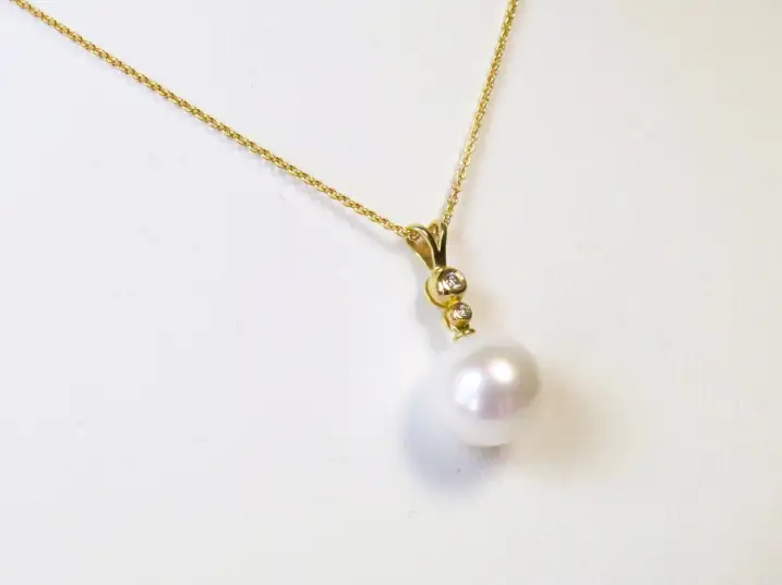 Nahaufnahme des echten Ming-Solitär-Anhängers mit 0,04ct Diamantbesatz aus der Perspektive von links zur Darstellung der makellosen Oberfläche.