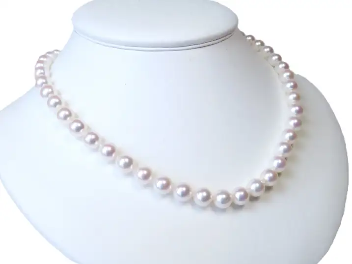 Das klassische Akoyaperlen-Collier auf einer Präsentationsbüste, fotografiert aus der Perspektive von schräg rechts
